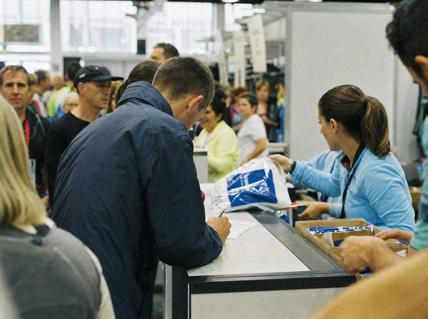 Runner collecting a race pack from volunteers at the marathon expo