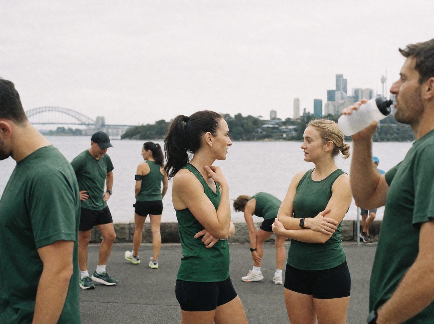 A running club in matching green shirts by Sydney Harbour