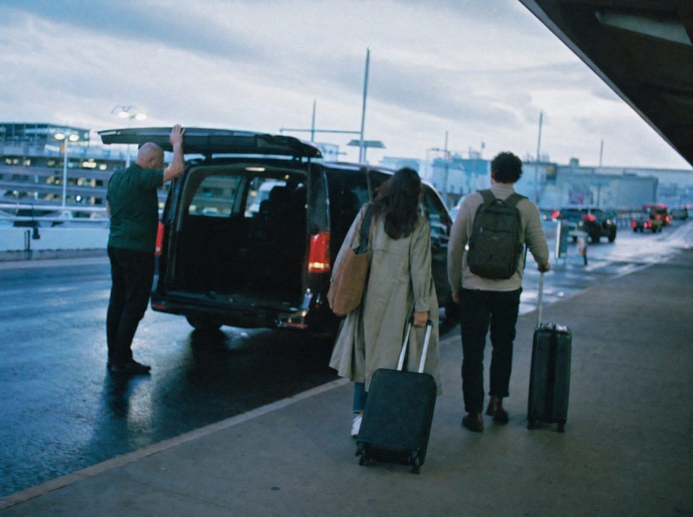 Driver loading luggage into a private transfer van at Sydney Airport